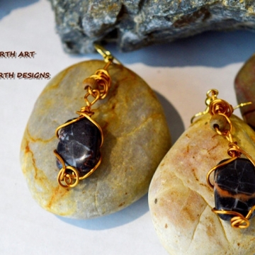 Banded BC agate drops hand wired with gold anodized copper wire there is a light oak bead mounted on the body it features gold ear wires